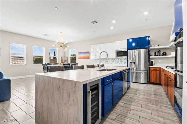 103 Reflection Cove Dr, Henderson, NV 89011 - kitchen featuring a sink, beverage cooler, a chandelier, appliances with stainless steel finishes, and visible vents