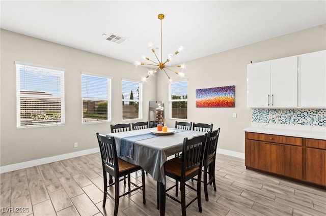103 Reflection Cove Dr, Henderson, NV 89011 - dining room featuring wood tiled floor, baseboards, a chandelier, and visible vents