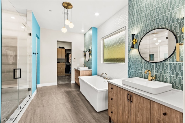 103 Reflection Cove Dr, Henderson, NV 89011 - bathroom featuring two vanities, a sink, a stall shower, baseboards, and a freestanding tub