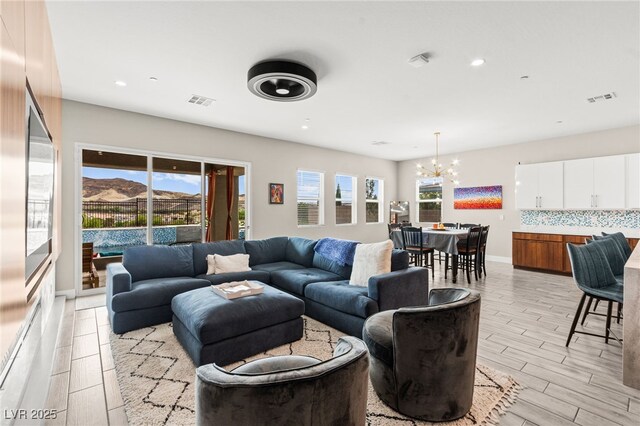 103 Reflection Cove Dr, Henderson, NV 89011 - living room with wood tiled floor, an inviting chandelier, visible vents, and recessed lighting