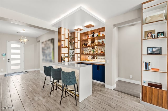 103 Reflection Cove Dr, Henderson, NV 89011 - bar featuring baseboards, decorative light fixtures, bar area, and wood tiled floor