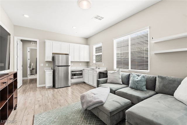 103 Reflection Cove Dr, Henderson, NV 89011 - living room with light wood-style flooring, visible vents, and baseboards