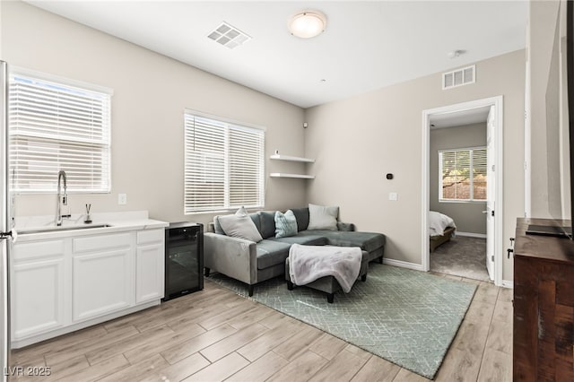 103 Reflection Cove Dr, Henderson, NV 89011 - living area with baseboards, light wood finished floors, wine cooler, and visible vents