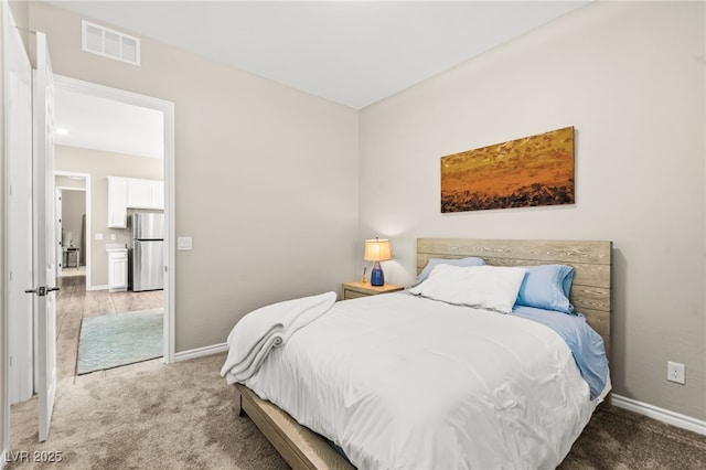 103 Reflection Cove Dr, Henderson, NV 89011 - bedroom featuring freestanding refrigerator, baseboards, visible vents, and light colored carpet