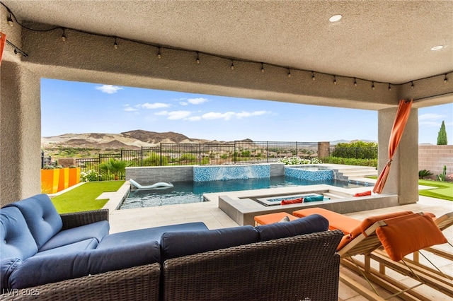 103 Reflection Cove Dr, Henderson, NV 89011 - view of pool with an outdoor living space, a patio area, a fenced backyard, a mountain view, and a pool with connected hot tub