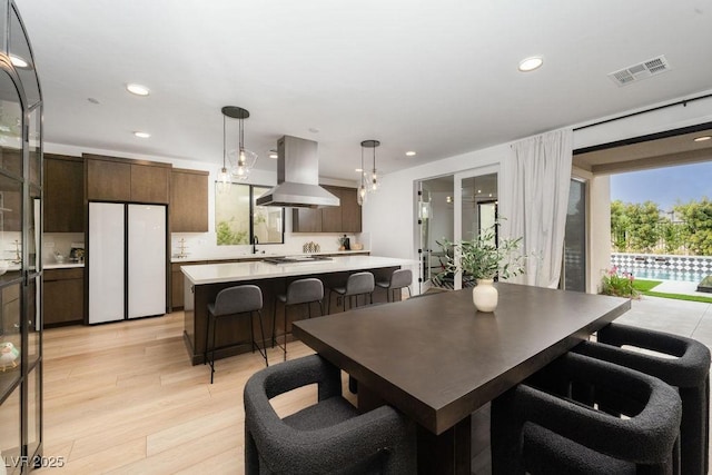 dining room featuring recessed lighting, light wood-style flooring, and visible vents