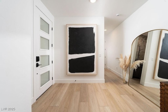 corridor with baseboards, light wood finished floors, and recessed lighting