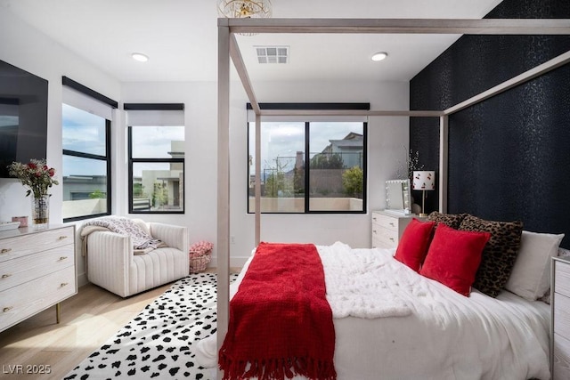 bedroom with light wood finished floors and visible vents