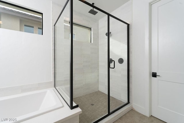 bathroom featuring a bath and a shower stall