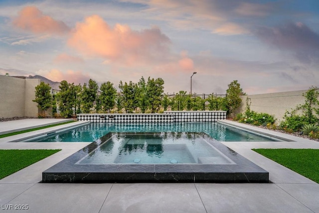 view of pool with a fenced backyard and a pool with connected hot tub