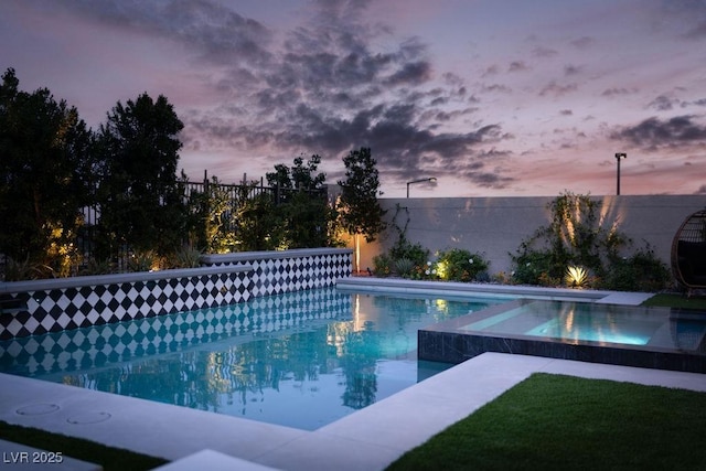 pool at dusk featuring fence and a fenced in pool