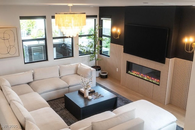 11990 Montague St, Las Vegas, NV 89138 - living room featuring wood finished floors, a glass covered fireplace, and a chandelier