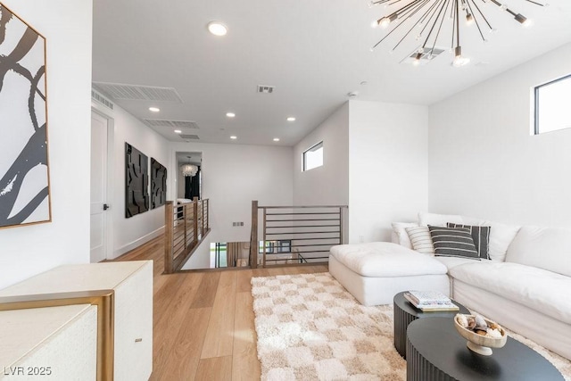 living room with a chandelier, light wood-style floors, visible vents, and recessed lighting