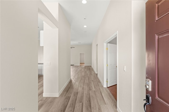 hallway featuring recessed lighting, light wood finished floors, and baseboards