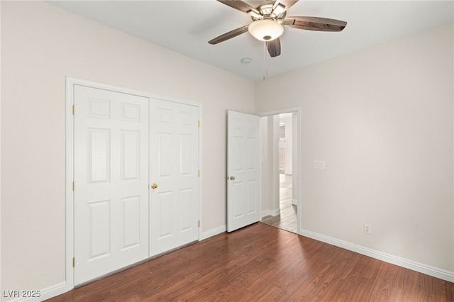unfurnished bedroom with baseboards, a ceiling fan, wood finished floors, and a closet