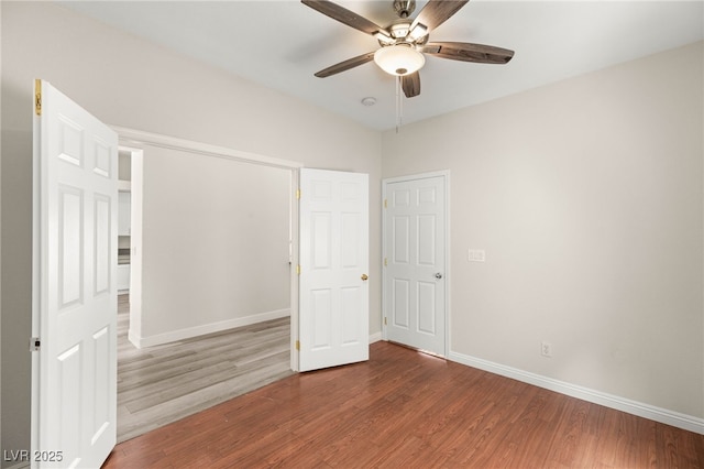 unfurnished bedroom featuring wood finished floors, baseboards, and a ceiling fan