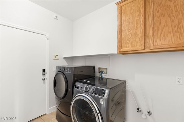 clothes washing area with light tile patterned flooring and washer and clothes dryer