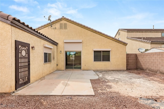 back of property with stucco siding, a patio, and fence private yard