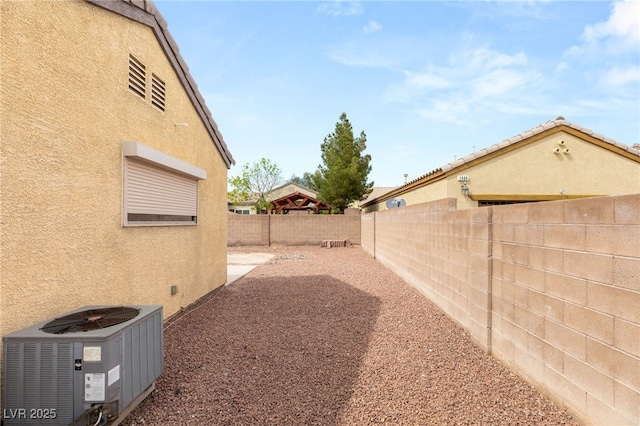 view of yard with a fenced backyard and central AC unit