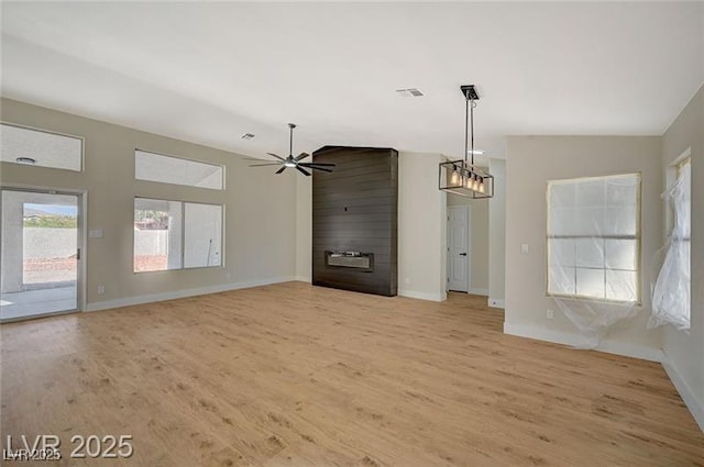 unfurnished dining area featuring light wood-type flooring, vaulted ceiling, baseboards, and visible vents