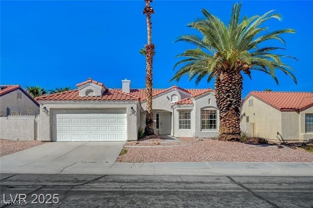 mediterranean / spanish house featuring fence, a tiled roof, stucco siding, driveway, and a garage