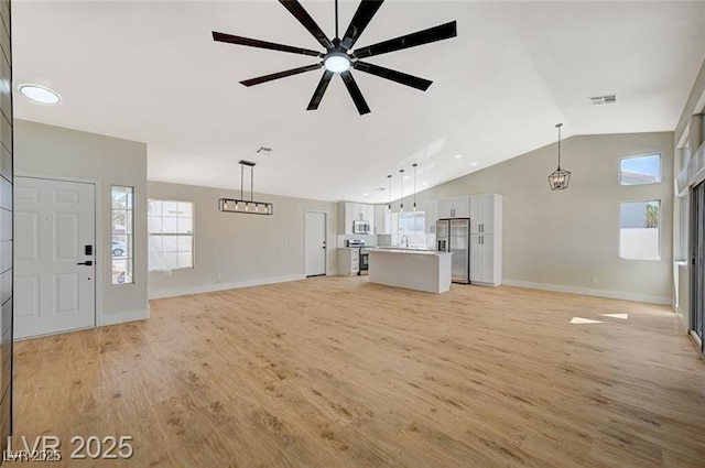 unfurnished living room featuring ceiling fan, baseboards, lofted ceiling, and light wood finished floors