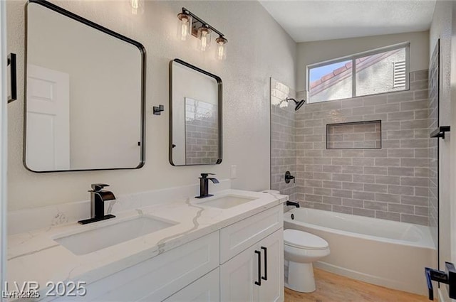 bathroom featuring toilet, bathtub / shower combination, wood finished floors, and a sink