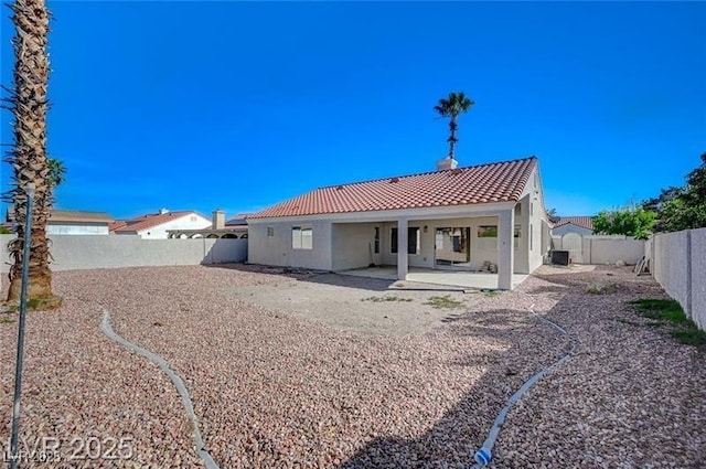 rear view of property with a patio area, a tile roof, a fenced backyard, and stucco siding
