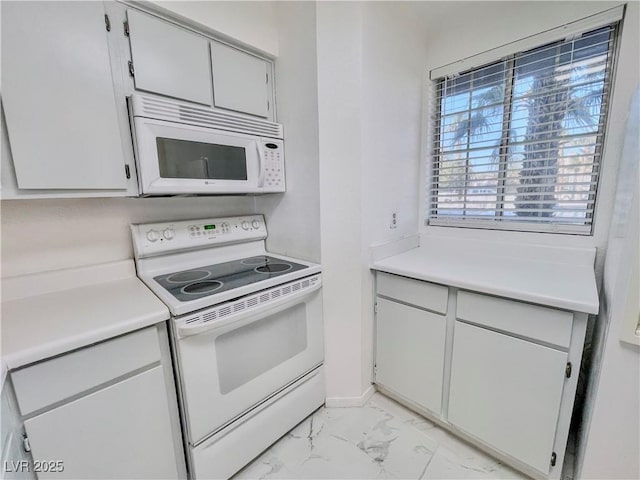 kitchen with light countertops, marble finish floor, and white appliances