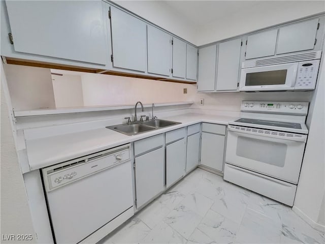 kitchen featuring a sink, white appliances, marble finish floor, light countertops, and gray cabinetry