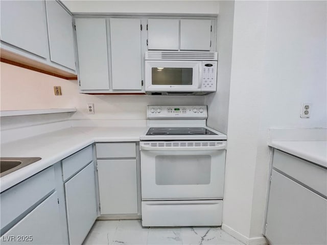 kitchen featuring light countertops, marble finish floor, and white appliances