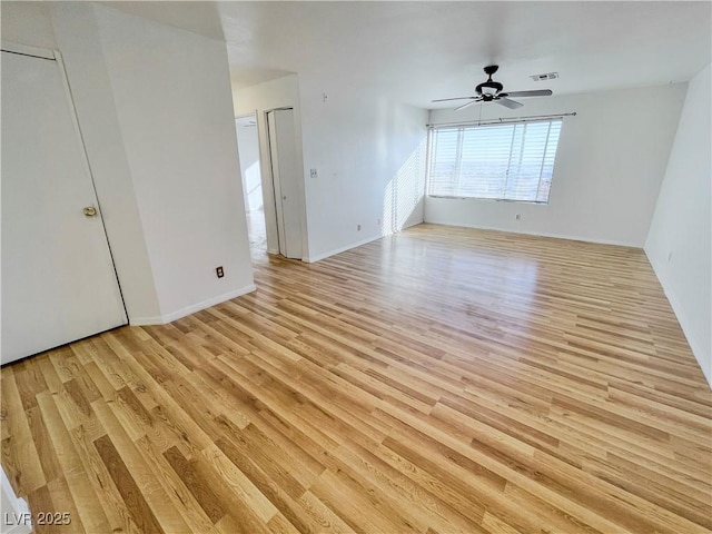interior space featuring visible vents, light wood finished floors, baseboards, and ceiling fan
