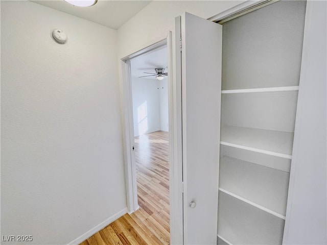 hallway with baseboards and wood finished floors