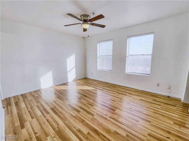empty room with light wood-type flooring, a ceiling fan, and baseboards
