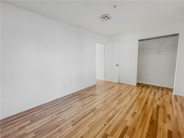unfurnished bedroom with a closet, visible vents, and light wood finished floors