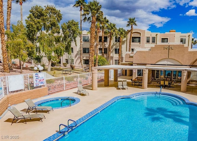 pool featuring a patio area, a hot tub, and fence