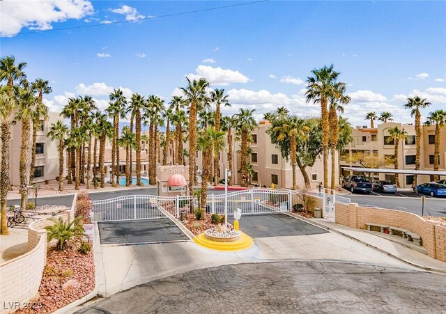 view of road with a gated entry, curbs, a gate, and a residential view