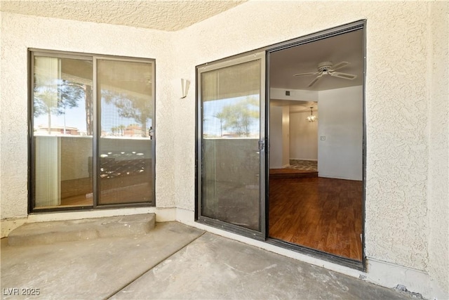 entrance to property featuring a patio area and stucco siding