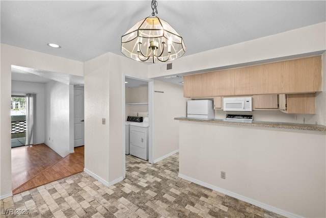 kitchen with light brown cabinetry, visible vents, baseboards, white appliances, and independent washer and dryer