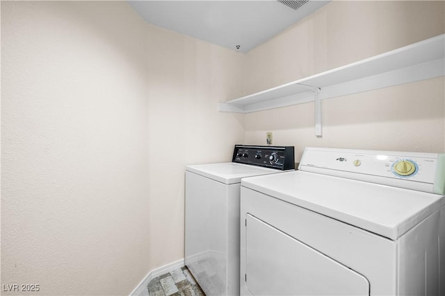laundry area featuring washing machine and clothes dryer, baseboards, and laundry area