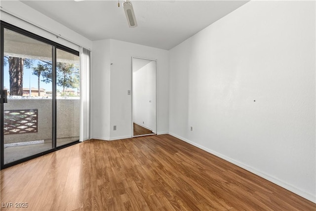 empty room featuring ceiling fan, baseboards, and wood finished floors