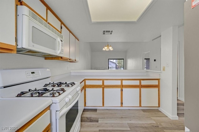 2819 Bluebonnet Dr Unit 6, Henderson, NV 89074 - kitchen featuring white appliances, light countertops, light wood finished floors, and hanging light fixtures