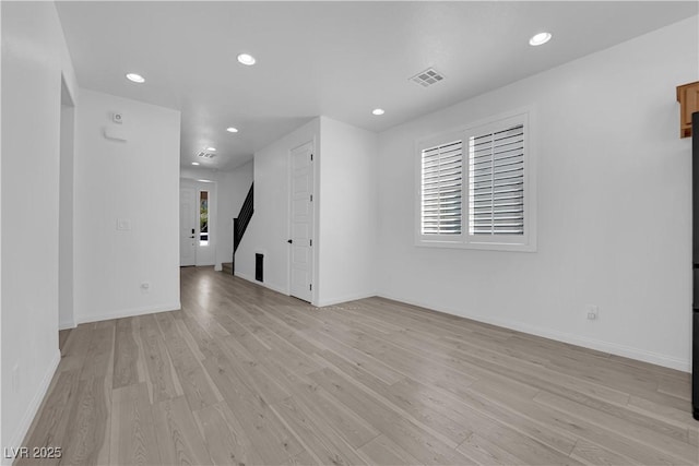 spare room featuring light wood finished floors, recessed lighting, and baseboards