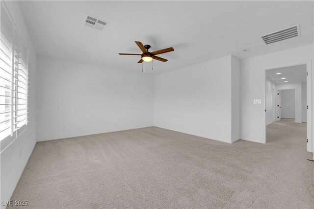 carpeted empty room with a ceiling fan