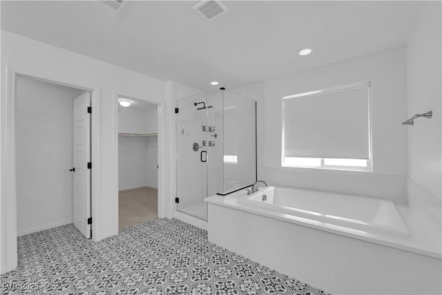 bathroom with a garden tub, a spacious closet, a stall shower, recessed lighting, and tile patterned flooring