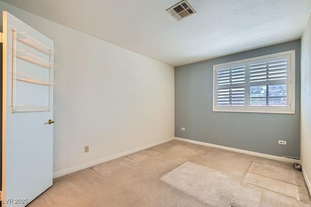 spare room with baseboards, carpet flooring, and visible vents