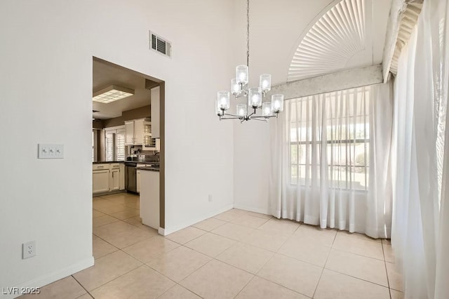 unfurnished dining area with baseboards, visible vents, light tile patterned floors, and an inviting chandelier