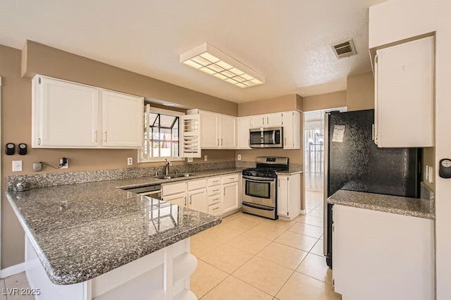 kitchen featuring white cabinets, a peninsula, a sink, and appliances with stainless steel finishes
