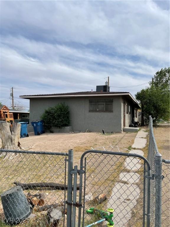 exterior space featuring a gate, stucco siding, and fence
