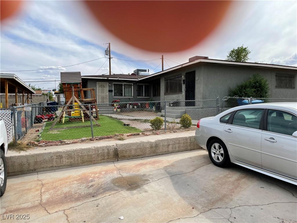 view of front facade featuring a playground and fence private yard